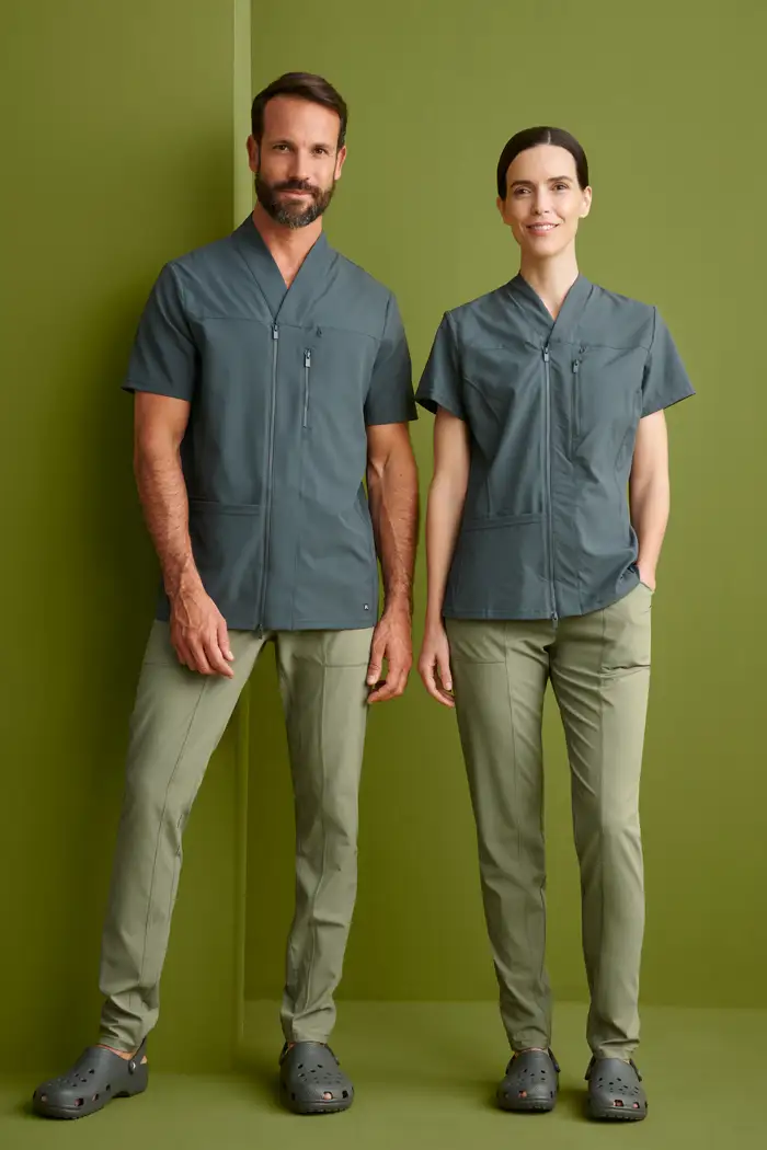Conjunto de uniformes para farmacia en Gran Canaria. Hombre y mujer con camisola sanitaria gris de cremallera y pantalón oliva.