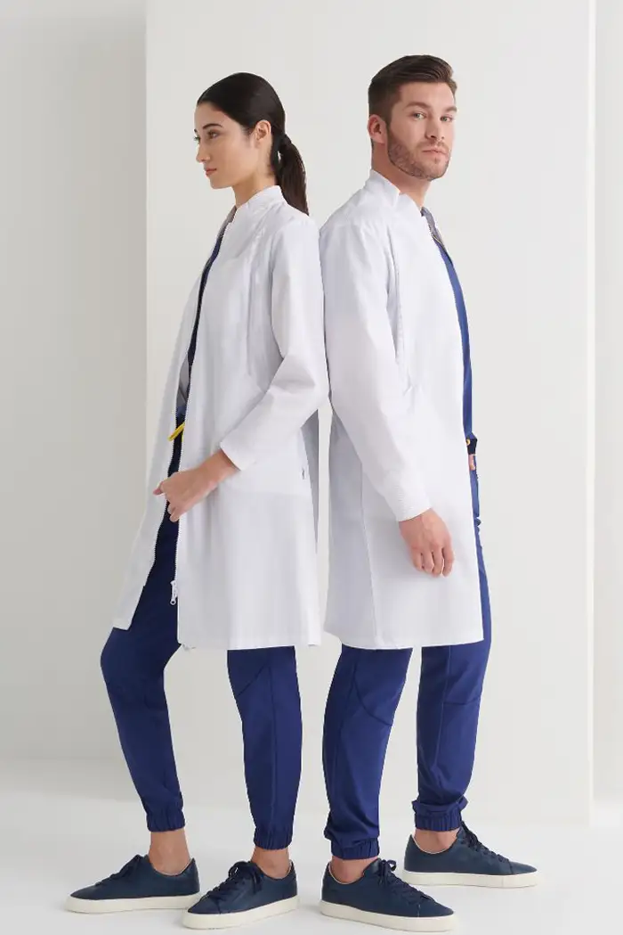Batas médicas blancas de laboratorio para profesionales. Profesionales de la salud luciendo batas para farmacia en Las Palmas sobre uniformes azules.