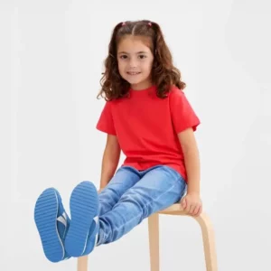 Niña sentada con camiseta Mukua PALM KIDS TS190KC coral de manga corta y cuello redondo.