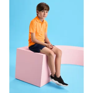 Polo Roly MONZHA en naranja flúor, vista frontal con modelo infantil