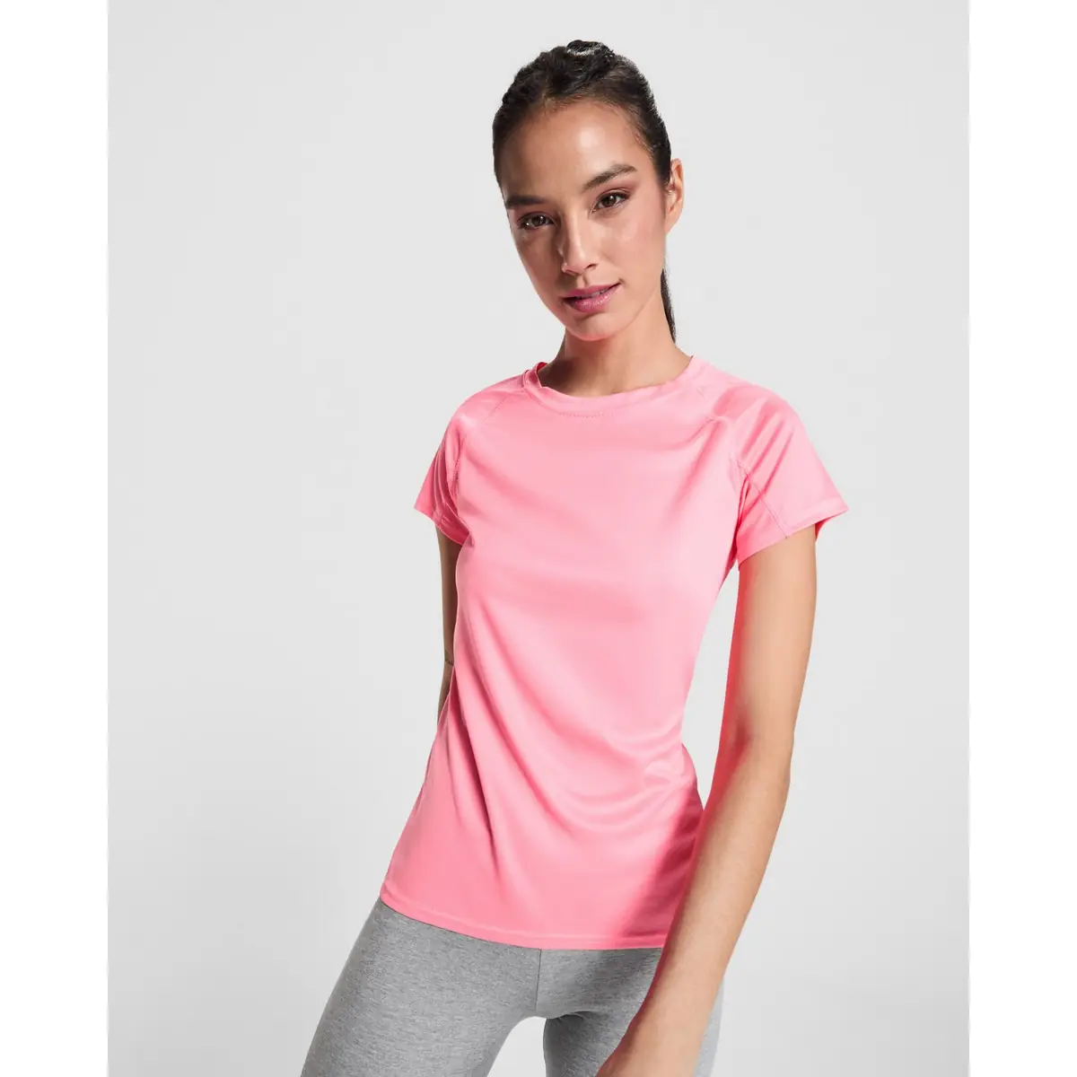 Camiseta técnica Mujer Roly BAHRAIN WOMAN 1 Camiseta Roly 0408 de manga corta en rosa, vista frontal sobre una modelo.