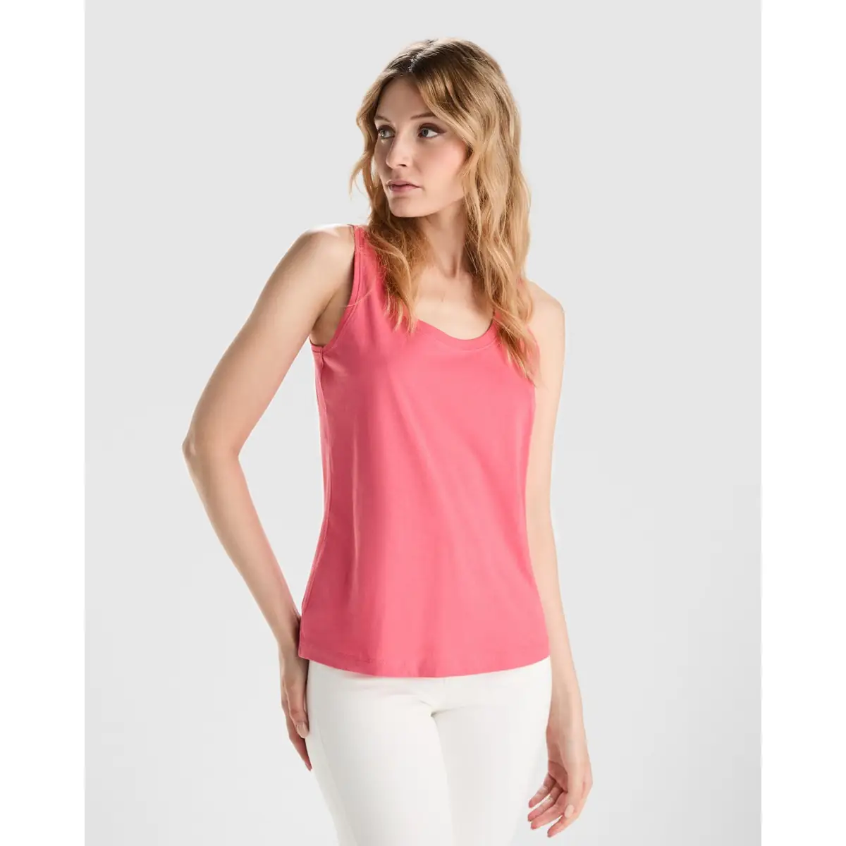 Camiseta de tirantes Mujer Roly NARA 1 Camiseta Roly 6536 de tirantes en rosa coral, vista frontal sobre una modelo.
