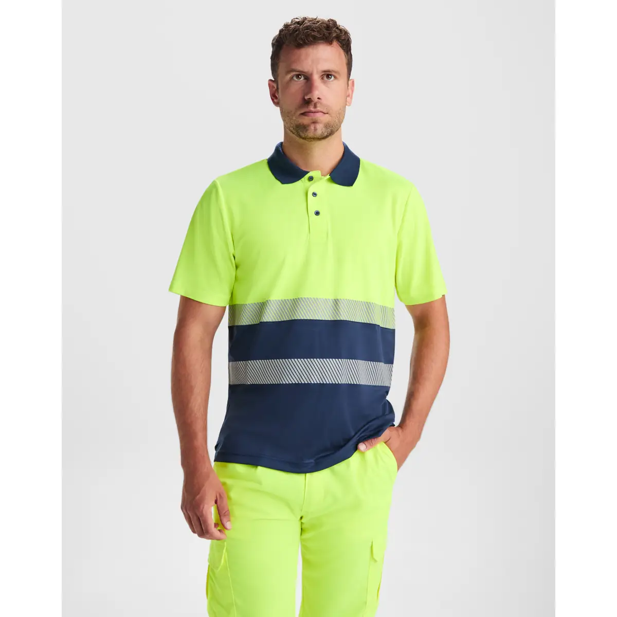 Polo alta visibilidad manga corta Roly VEGA 1 Polo Roly VEGA en azul marino y amarillo flúor, vista frontal con modelo