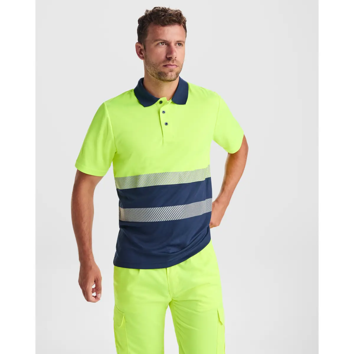 Polo alta visibilidad manga corta Roly VEGA 2 Polo Roly VEGA en azul marino y amarillo flúor, vista frontal con modelo