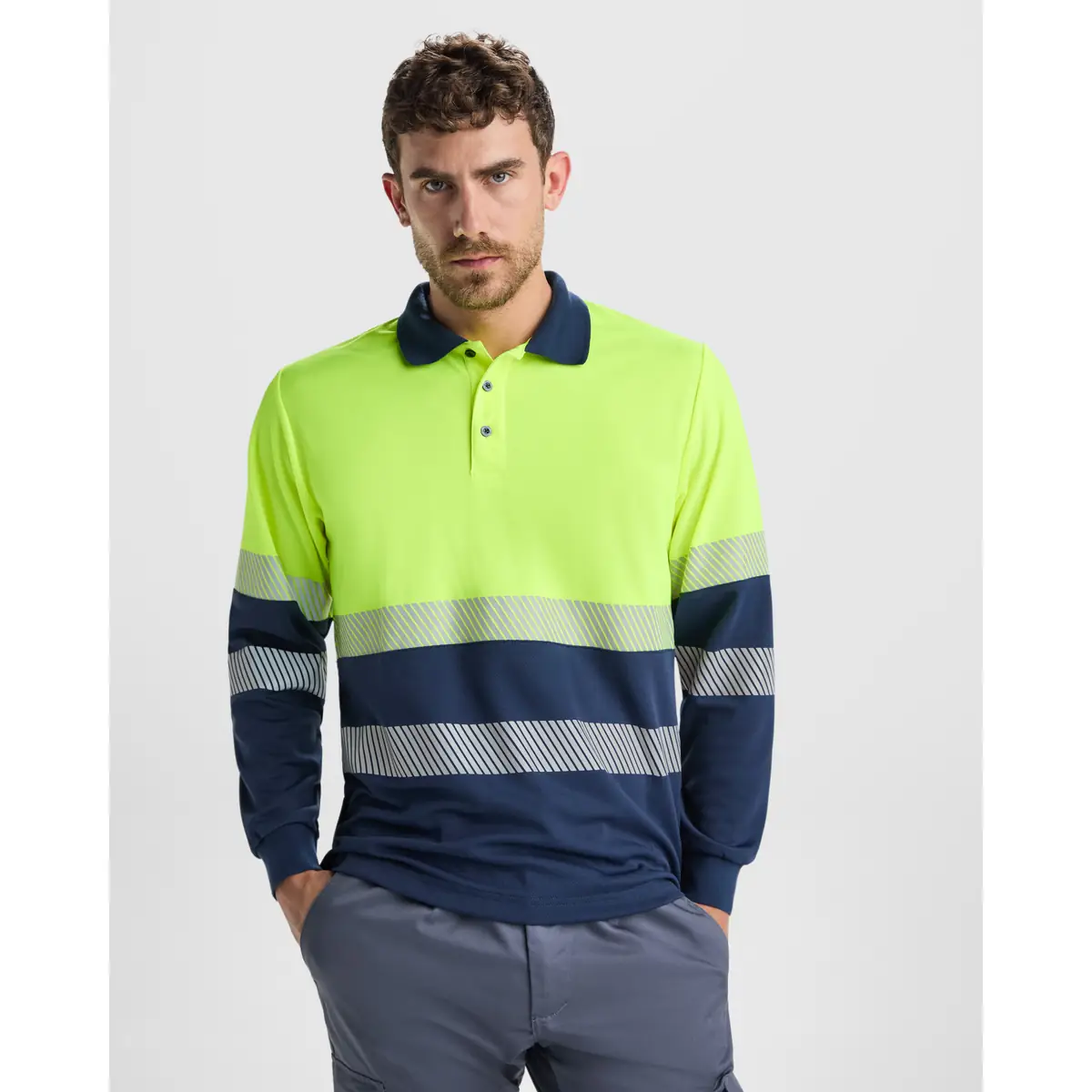 Polo alta visibilidad manga larga Roly VEGA LS 2 Polo Roly VEGA LS en azul marino y amarillo flúor de manga larga, vista frontal con modelo