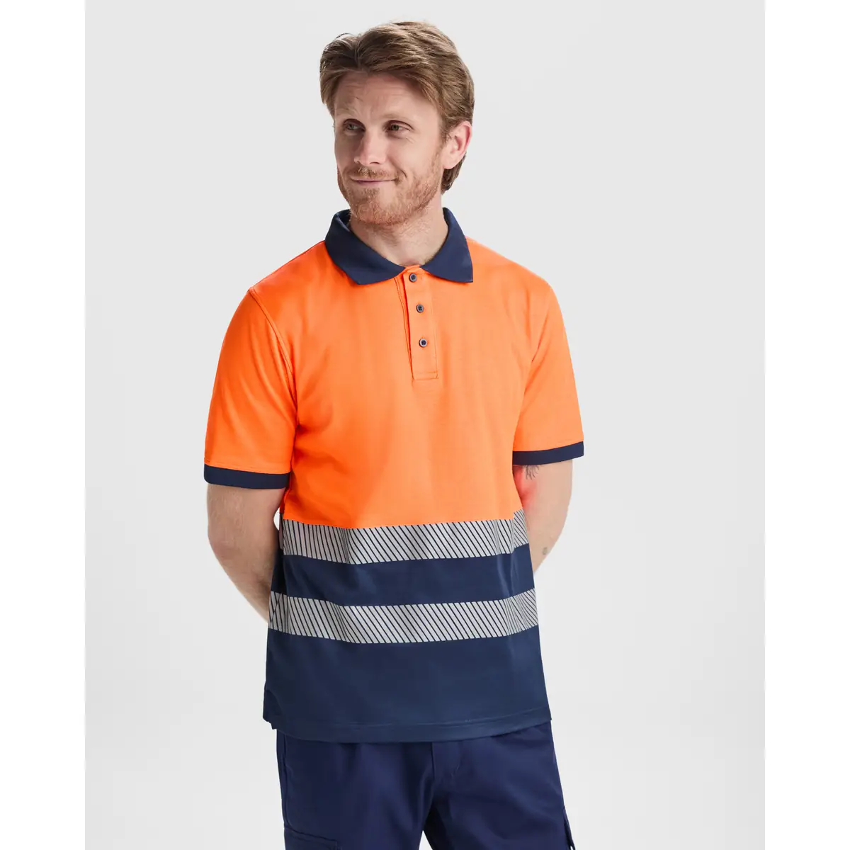 Polo alta visibilidad manga corta Roly ATRIO 1 Polo Roly ATRIO en azul marino y naranja flúor, vista frontal con modelo