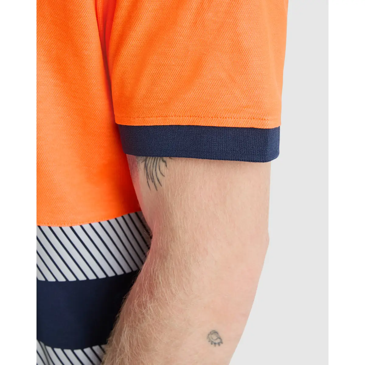 Polo alta visibilidad manga corta Roly ATRIO 2 Polo Roly ATRIO en azul marino y naranja flúor, detalle del remate de la manga