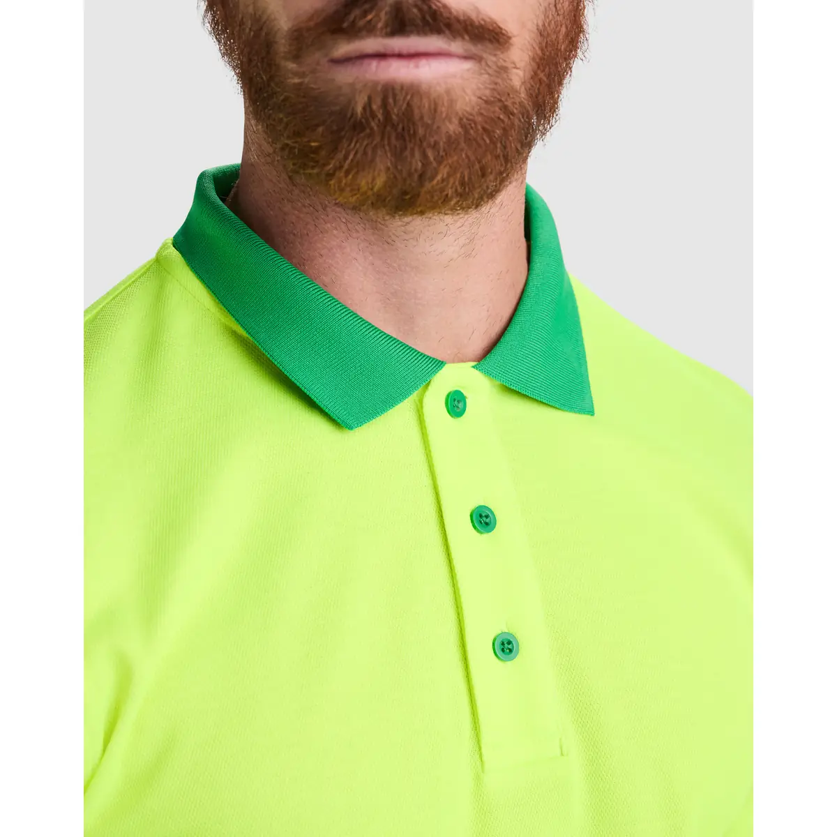 Polo alta visibilidad manga larga Roly ATRIO LS 7 Polo Roly ATRIO LS en verde jardín y amarillo flúor, detalle del cuello y la tapeta