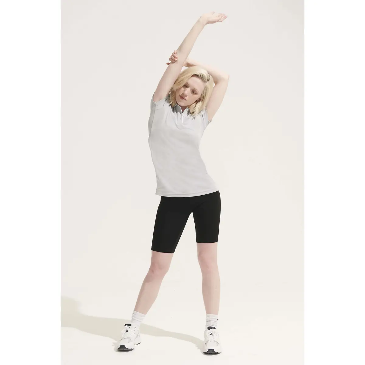 Polo mujer SOL’S PERFORMER WOMEN 01179 28 Polo Sol’s PERFORMER WOMEN gris claro, vestido por una modelo con los brazos elevados
