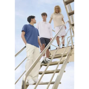 Polo Sol’s PULSE azul, vestido por un modelo junto a otros dos modelos en una escalera