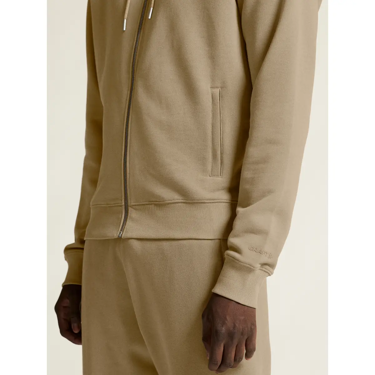 Sudadera hombre CRAFT FREQUENT FZ HOODIE 1916306 23 Sudadera hombre CRAFT FREQUENT FZ HOODIE 1916306, Taupe, con modelo, detalle del bolsillo y el puño