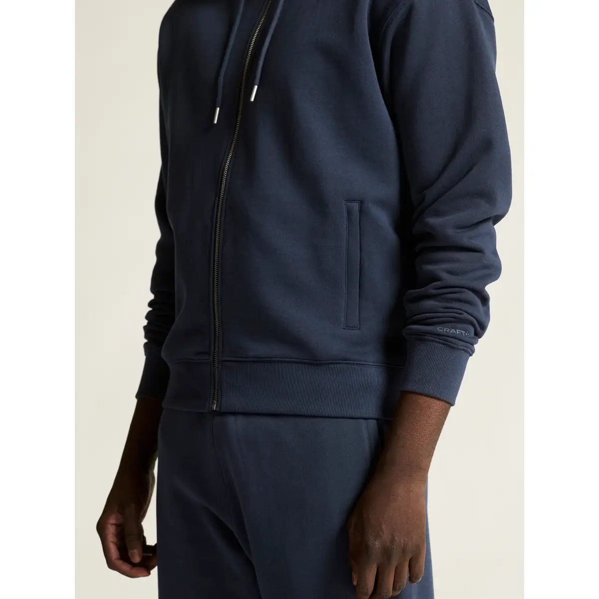 Sudadera hombre CRAFT FREQUENT FZ HOODIE 1916306 26 Sudadera hombre CRAFT FREQUENT FZ HOODIE 1916306, Blaze, con modelo, detalle del bolsillo y el puño