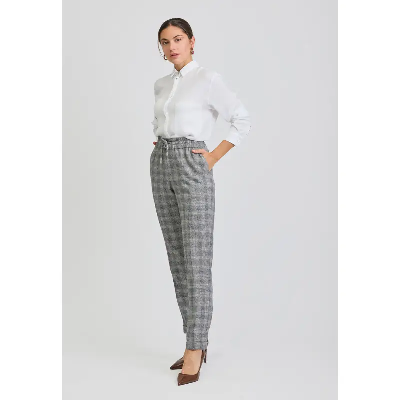 Pantalón jogger unisex artia Norvil 74 2 Pantalón jogger unisex artia Norvil 74 en cuadro negro/beige, vista de tres cuartos, sobre modelo.
