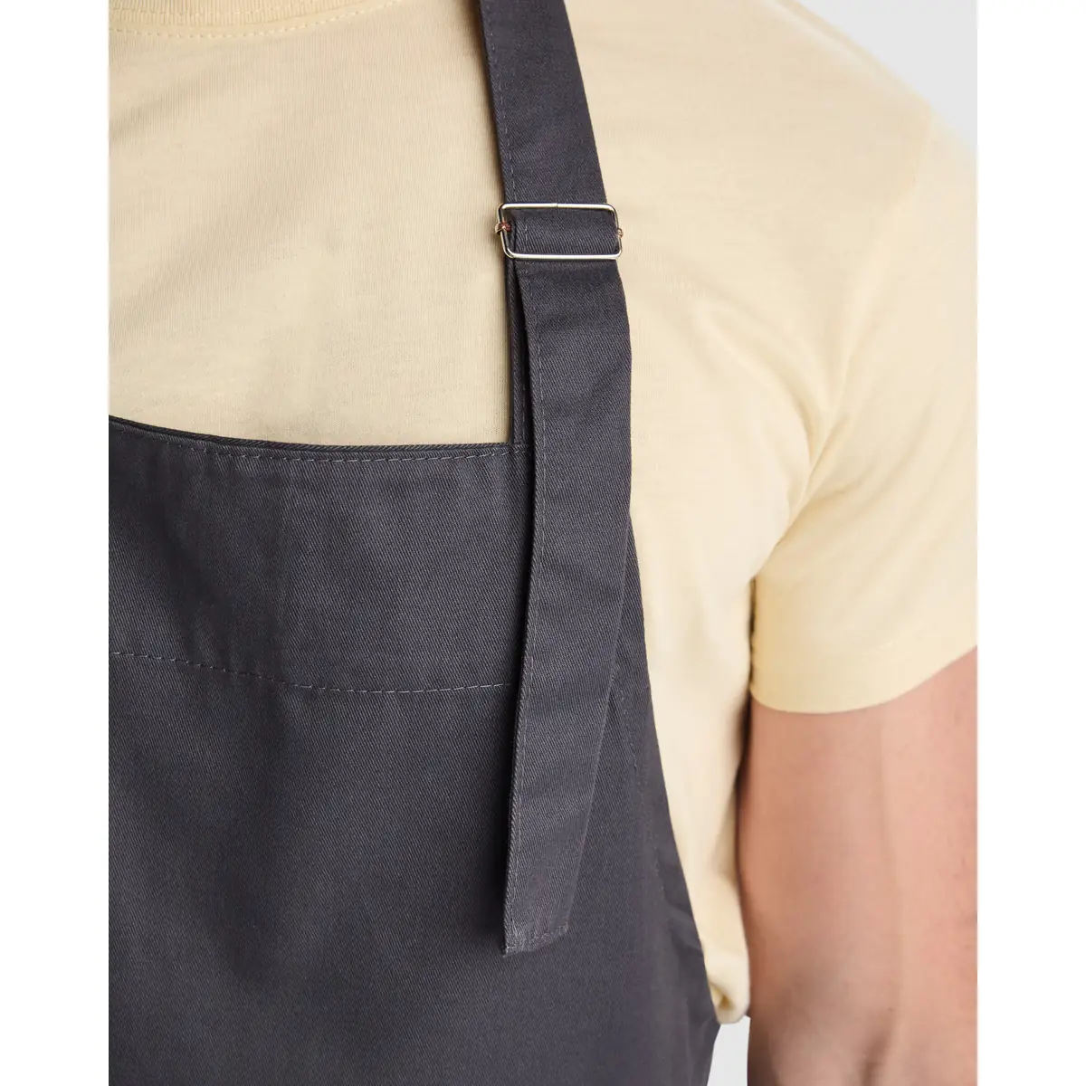 Delantal reciclado Roly WRK Bost 9139 2 Delantal reciclado Roly WRK Bost 9139, gris oscuro, detalle del ajustador de cuello con modelo