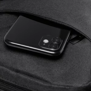 Bandolera RPET Stamina Klein 1027, negro, detalle del bolsillo frontal con un teléfono como ejemplo de uso