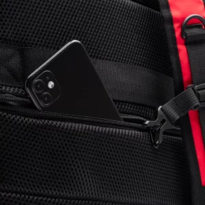 Mochila de viaje RPET Stamina Banter 1347, rojo, detalle del bolsillo posterior con un teléfono como ejemplo de uso