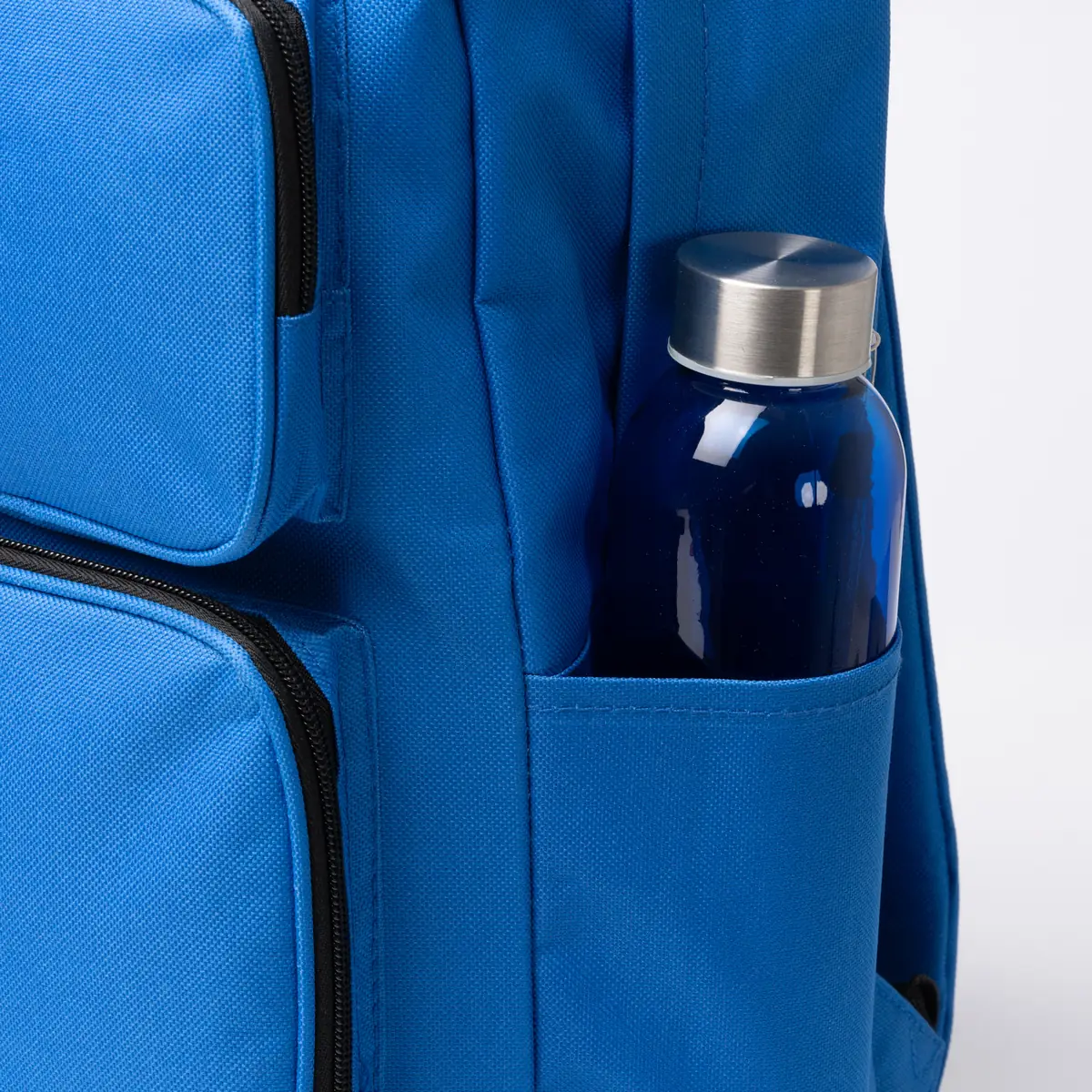 Mochila de RPET Stamina Hostik 1664 9 Mochila de RPET Stamina Hostik 1664, royal, detalle del bolsillo lateral con una botella como ejemplo de uso