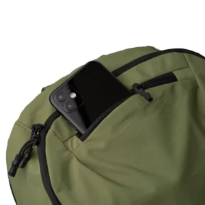 Mochila de nylon Stamina Vermont 1865, verde oscuro, detalle del bolsillo frontal con un teléfono como ejemplo de uso