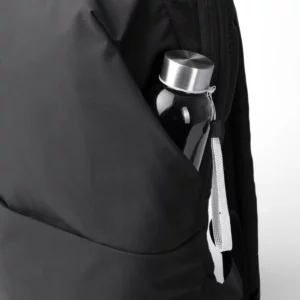 Mochila de viaje Stamina Dakota 1866, negro, detalle del bolsillo lateral con una botella como ejemplo de uso