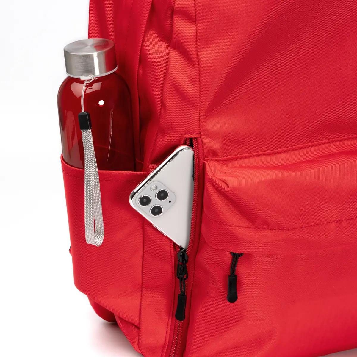 Mochila de nylon reciclado Stamina Tomin 1868 8 Mochila de nylon reciclado Stamina Tomin 1868, rojo, detalle de los bolsillos con una botella y un teléfono como ejemplo de uso