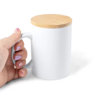 Taza de cerámica con tapa Stamina Berry 4012, blanco, vista de una mano sujetando la taza con tapa por el asa