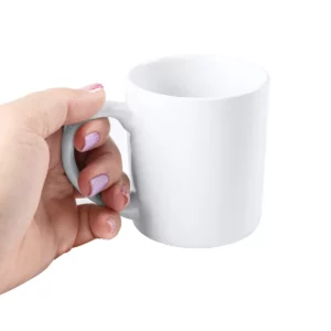 Taza de cerámica para sublimar Stamina Marang 4084, blanco, vista de una mano sujetando la taza por el asa